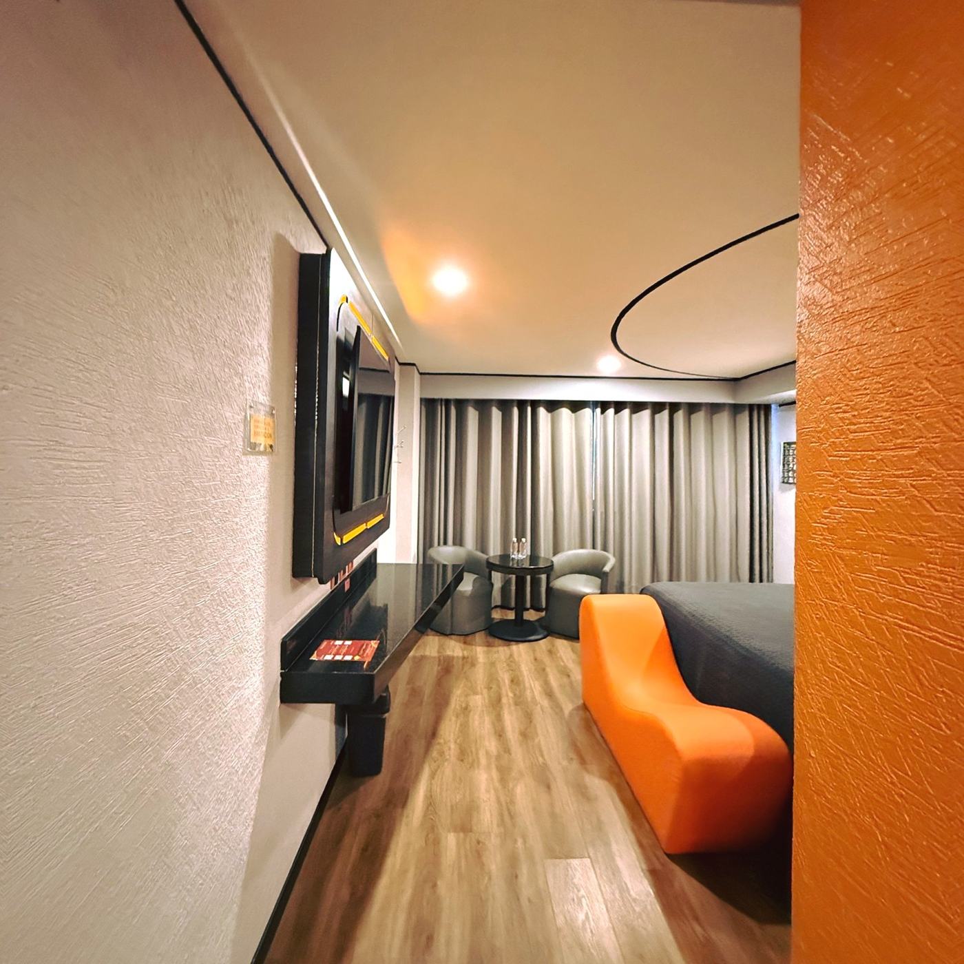 Habitación con diván naranja y muro de color