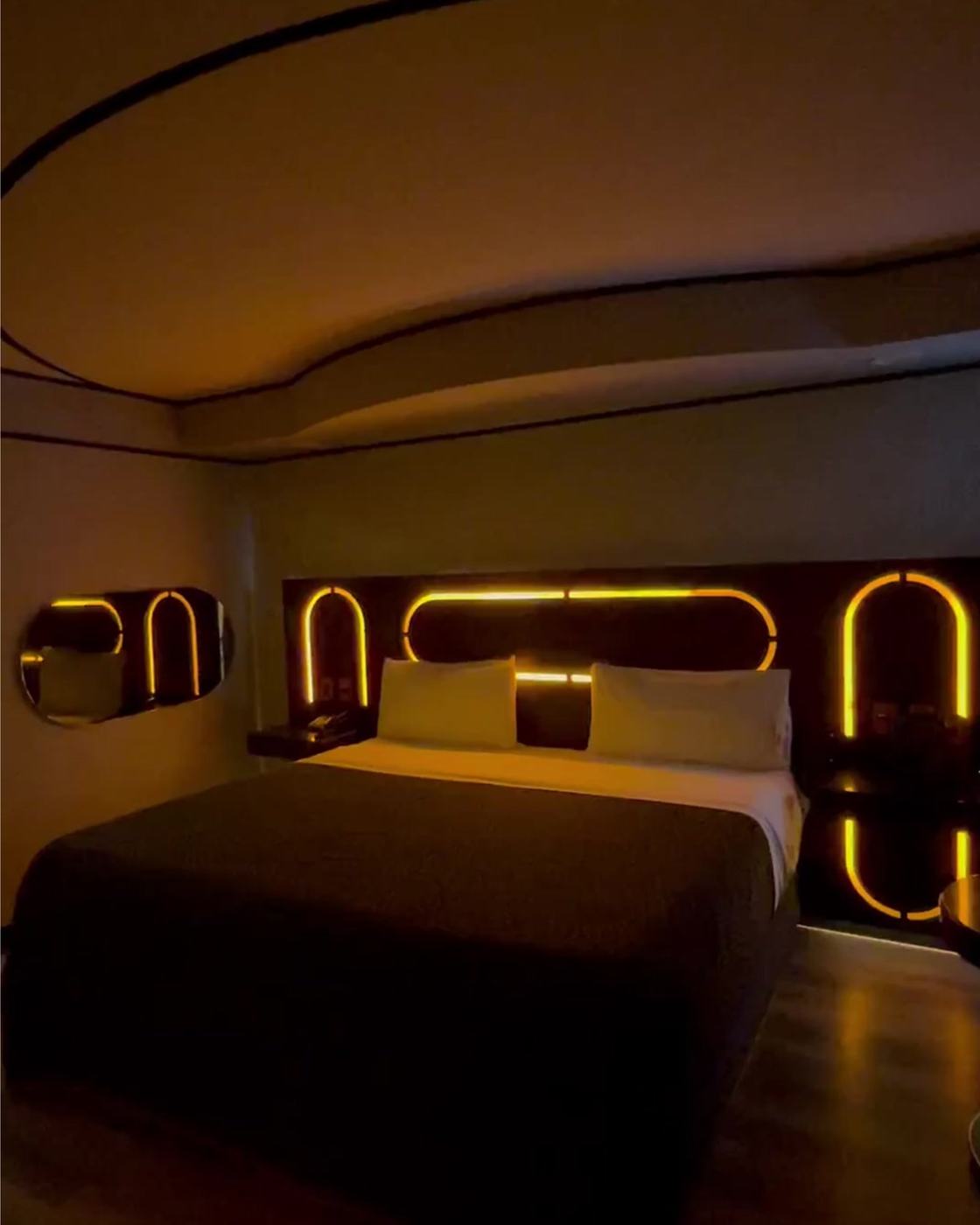 Habitación con cabecera iluminada en ámbar